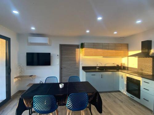 une cuisine avec une table noire et des chaises dans l'établissement Nid douillet et moderne, à Beauménil