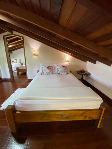a large bed in a room with a wooden ceiling at Casa para temporada em Paraty RJ - Sítio Primavera in Paraty