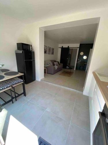 ein Wohnzimmer mit einem großen Fliesenboden und einem Kühlschrank in der Unterkunft Joli studio de vacances vue mer in Sausset-les-Pins