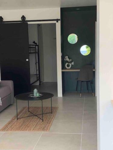 un salon avec une table et un canapé dans l'établissement Joli studio de vacances vue mer, à Sausset-les-Pins