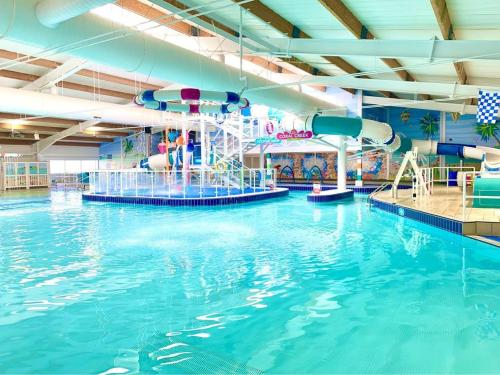 a large indoor swimming pool with a water slide at Riverwood Lodge, The Boulevard, Seal Bay, Selsey in Selsey