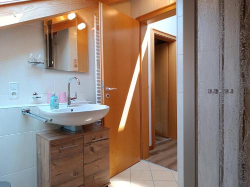 La salle de bains est pourvue d'un lavabo et d'un miroir. dans l'établissement Gipfelblick, à Ofterschwang