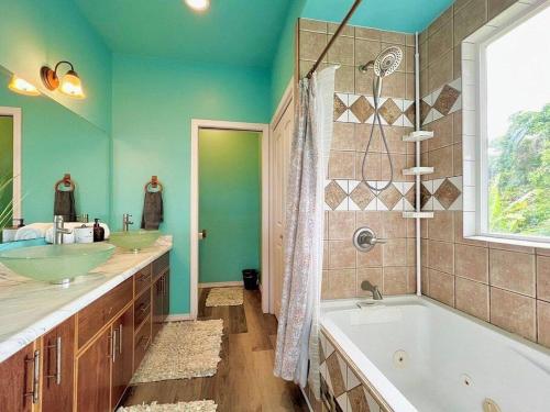a bathroom with two sinks and a tub and a window at THE HONOMU HOUSE - Gorgeous, Spacious 4Bd2Ba Home near Waterfalls and Hilo, Sleeps 12! in Honomu