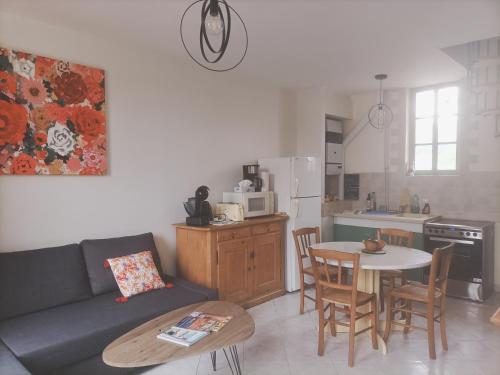 uma sala de estar com um sofá, uma mesa e uma cozinha em La Maison des Magnolias em Trouville-sur-Mer