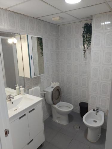 een witte badkamer met een toilet en een wastafel bij Apartamento Florido in Torremolinos