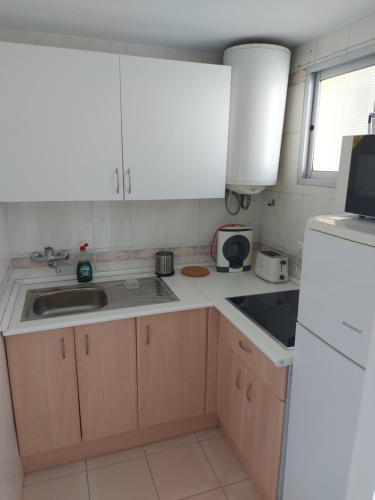 een keuken met een wastafel en een witte koelkast bij Apartamento Florido in Torremolinos