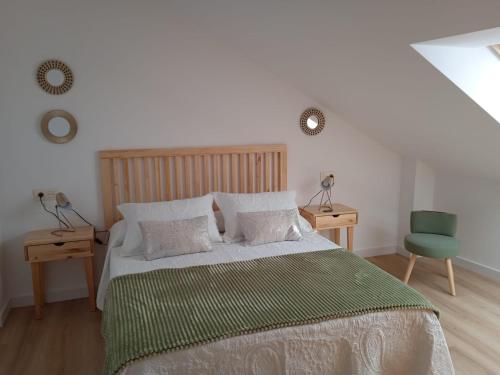 1 dormitorio con 1 cama y 1 silla verde en Amaral Xunqueiras en Pobra do Caramiñal