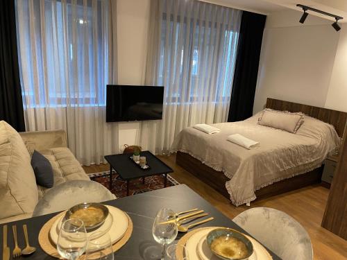 een woonkamer met een bed en een tafel met eten erop bij Central Apartment Prishtina in Pristina