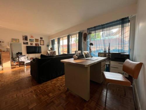 - un salon avec un bureau et un ordinateur portable dans l'établissement Grand appartement avec balcon et parking gratuit sur place, à Paris