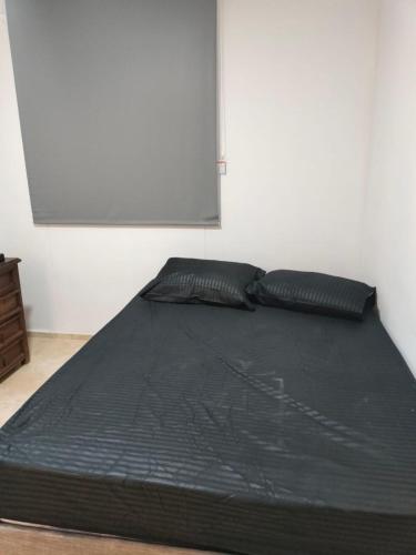 1 cama negra con 2 almohadas en una habitación en Habitación en Cartagena, en Cartagena de Indias