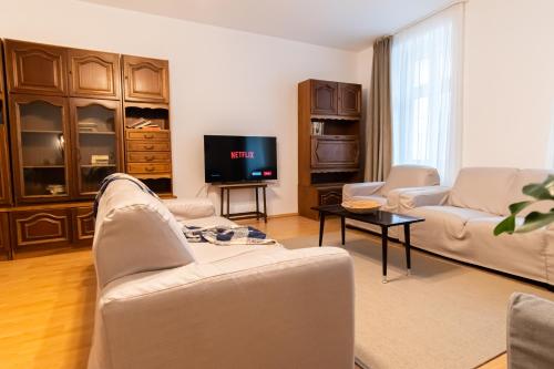 - un salon avec deux canapés et une télévision dans l'établissement Radu's - Traditional Ultracentral Apartment in the Old Town, à Braşov