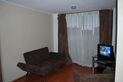 een woonkamer met een bank en een televisie bij Apartamento Don Rodolfo in Antofagasta