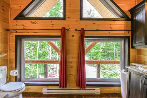 ein Badezimmer mit zwei Fenstern in einem Blockhaus in der Unterkunft Brown Bear Lodge in Brownsburg