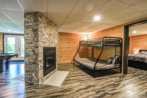 Brown Bear Lodge في Brownsburg: غرفة بها موقد وسرير بطابقين