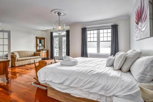 een witte slaapkamer met een groot wit bed met witte kussens bij LaBelle View in Labelle