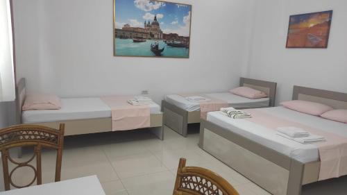 a room with three beds and a table and chairs at Vila Juna in Ksamil