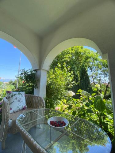 - une table en verre avec un bol de fruits sur la terrasse dans l'établissement Green Paradise Villa, à Peje