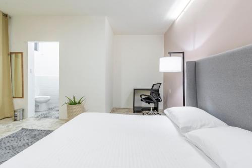 a white bedroom with a bed and a desk at Casa Marina Habitacion Seattle in Acámbaro