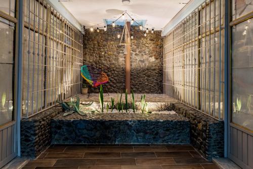 Pokój z kamienną ścianą i stołem z roślinami w obiekcie Casa Marina Habitacion Seattle w mieście Acámbaro