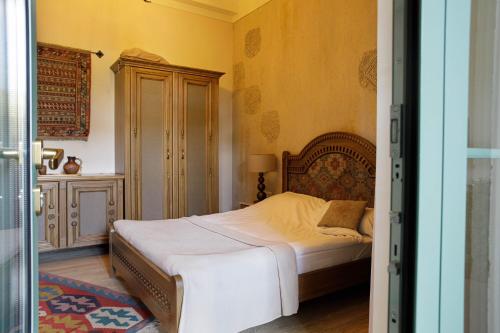 a bedroom with a bed in a room with yellow walls at Boutique ETHNO HOTEL in Gyumri