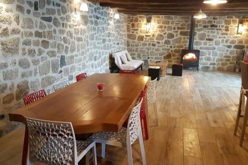 Buron isolé sur l'Aubrac في لاغيول: طاولة وكراسي خشبية في غرفة بها موقد