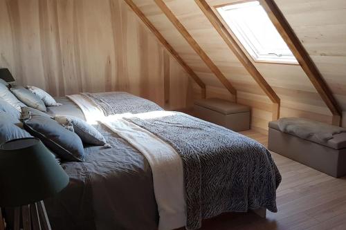 Buron isolé sur l'Aubrac في لاغيول: غرفة نوم بسرير ونافذة في العلية