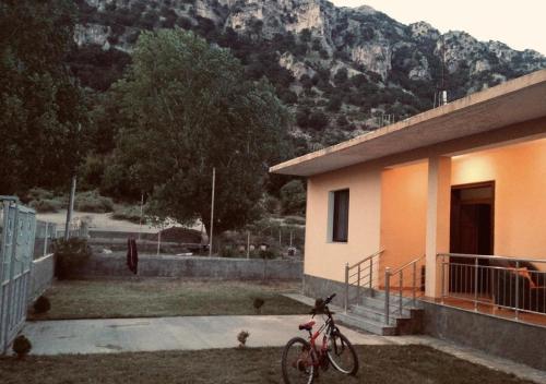una bicicleta estacionada frente a una casa con una montaña en TE SHPIA en Baks-Rrjoll