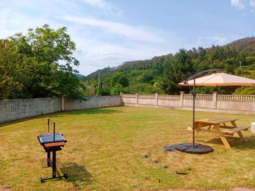 a grill and an umbrella in a yard at La Casa de Marina in Vivero