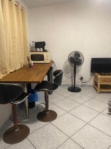 Pokój ze stołem, krzesłami i kuchenką mikrofalową w obiekcie Bungalow Pamatai Sky w mieście Faaa