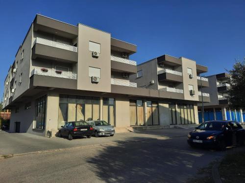 a building with two cars parked in front of it at Apartment Čapljina in Čapljina