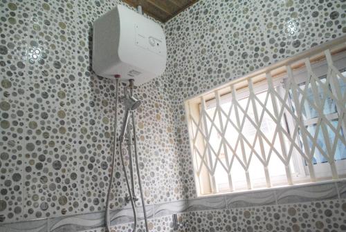 eine Kamera auf einem Stativ in einem Zimmer mit Fenster in der Unterkunft Comfort Home in Accra