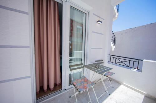 a balcony with a table and a chair next to a window at Hotel Olsi in Sarandë