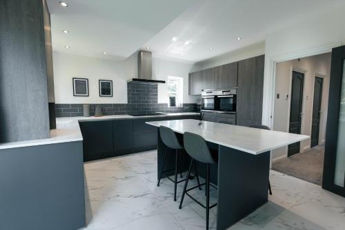a kitchen with a island with stools in it at Harbour House in Plymouth