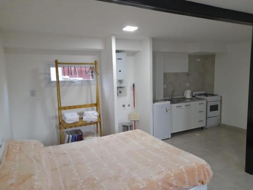 Habitación blanca con cama y cocina en BO Alquileres Temporarios en Ushuaia