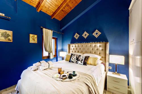 una camera blu con un letto e un vassoio di cibo sopra di Via Porta Raimonda (Luxury central detached house) a Città di Corfù