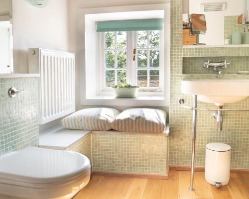 uma casa de banho com um WC, um lavatório e uma janela em The Coach House at Jervaulx em Ripon