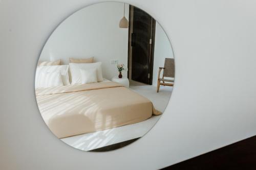 a bedroom with a bed in a round mirror at The Hut Hut in Uluwatu
