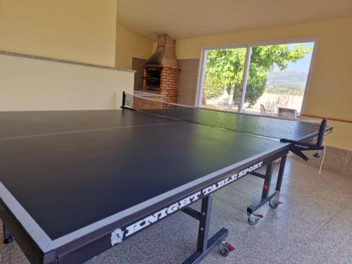 a ping pong table in a living room with a table tennis racket at Lugar de Levides 