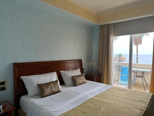 a bedroom with a bed with a view of the ocean at Gardenia Hotel in Lazzaro