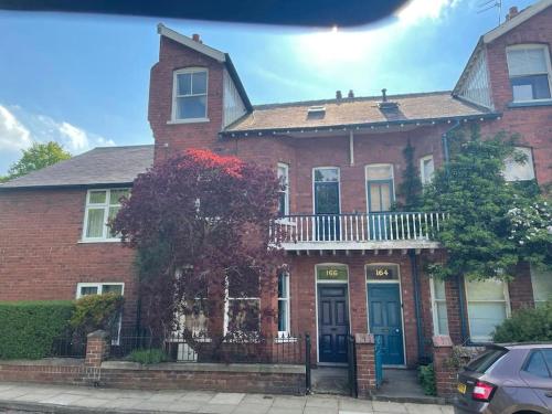 a red brick house with blue doors on a street at Knavesmire in York