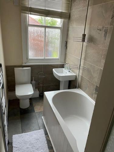 a bathroom with a tub and a toilet and a sink at Knavesmire in York