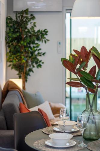 a table with glasses and a vase with flowers on it at Haven near Hagley Park, Hospital, Parakiore, Avon in Christchurch