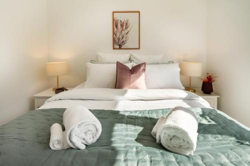 a bedroom with a bed with towels on it at Beautiful Gem by Hagley Park, Central City Chch in Christchurch