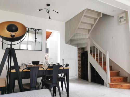 une salle à manger avec une table et un escalier dans l'établissement Gîte Chez Maupassant 6 à 8 personnes Fécamp, à Fécamp