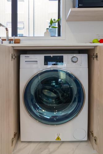 a washing machine with a blue glass door in a kitchen at Haven near Hagley Park, Hospital, Parakiore, Avon in Christchurch