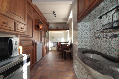un bagno con vasca e una cucina con tavolo di Casa Passeg dera Libertat 8 a Vielha