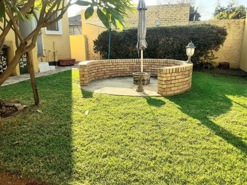 a backyard with a brick fountain in the grass at Carol Cottage Fun in Johannesburg