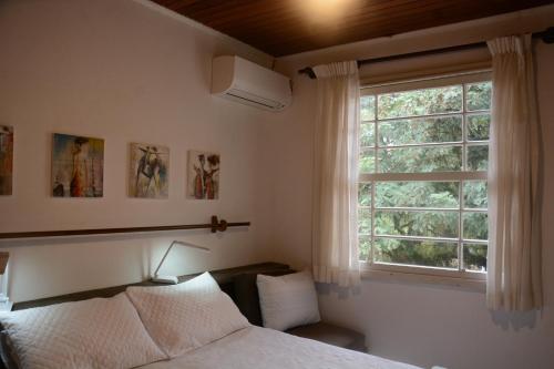 a bedroom with a bed and a window at Apartamento Kami in Porto Alegre