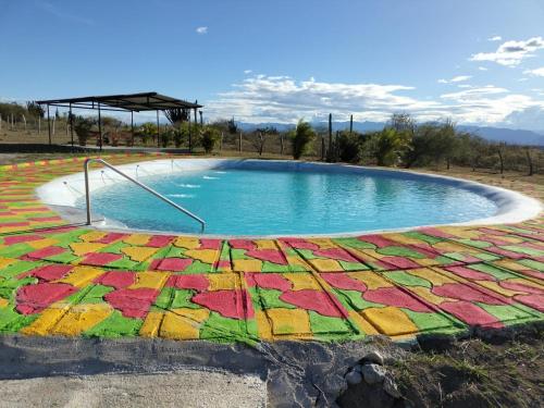 a swimming pool with a colorful quilt around it at Payande - Tatacoa in Villavieja