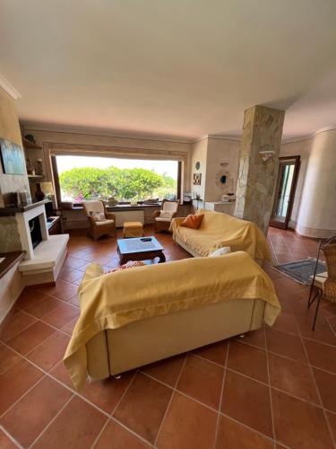 sala de estar amplia con 2 camas y chimenea en Villa Patrizia con piscina privata, en Stintino